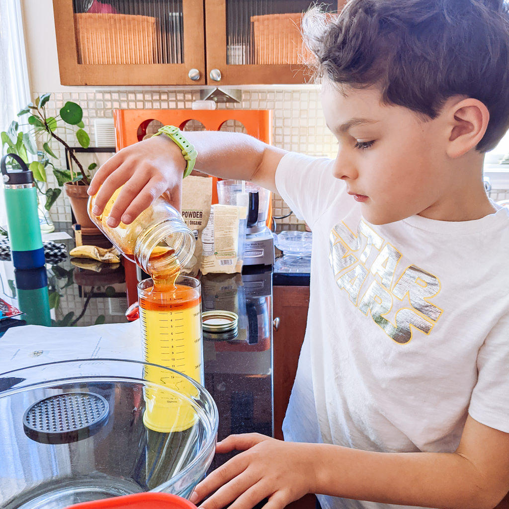 Liam pouring honey to make energy balls recipe. Copyright Merriment Design Co. Do not use without written permission.