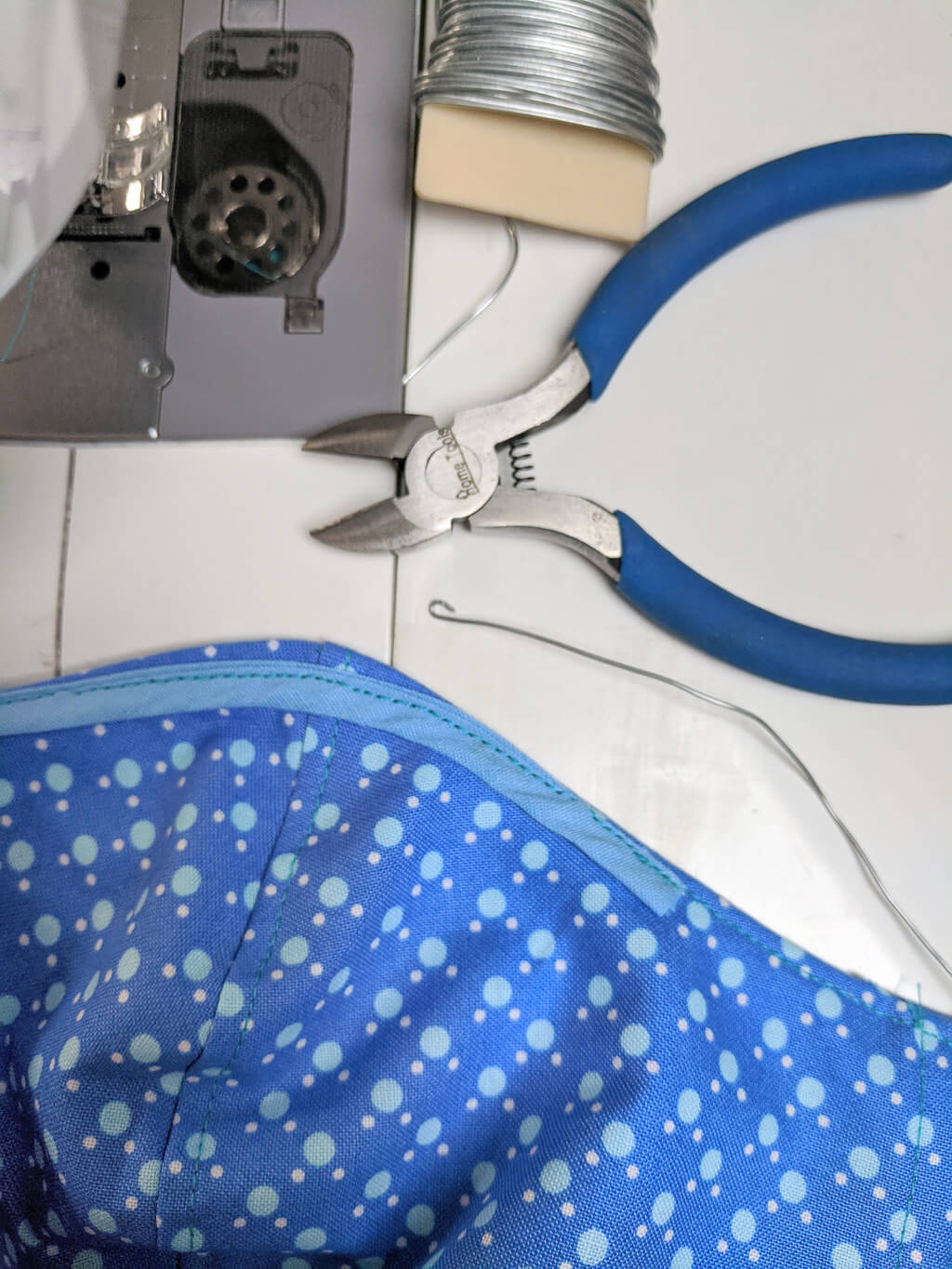 Curving end of wire to avoid poking in a fabric face mask