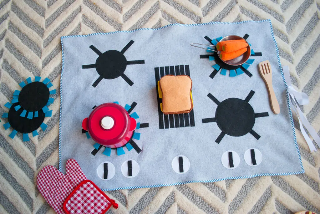 Felt stove DIY kids play kitchen with detachable felt "burners." It's flat, so you can put it anywhere and roll it up to store away. What a great kids DIY Christmas gift idea! | DIY play kitchen | DIY felt stovetop | DIY felt oven #diygifts #christmas #sewing #freesewingpattern #sewingpattern #DIY #diyforkids