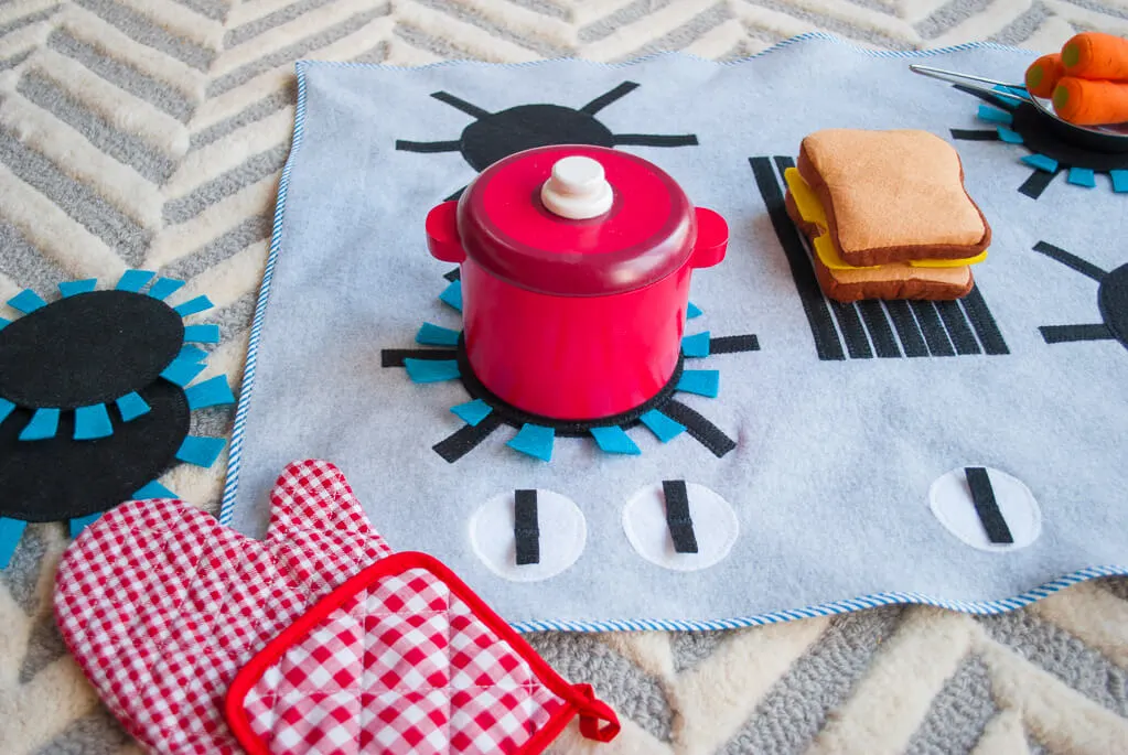 Felt and fleece stove DIY kids play kitchen with detachable felt "burners." It's flat, so you can put it anywhere and roll it up to store away. What a great kids DIY Christmas gift idea! | DIY play kitchen | DIY felt stovetop | DIY felt oven #diygifts #christmas #sewing #freesewingpattern #sewingpattern #DIY #diyforkids