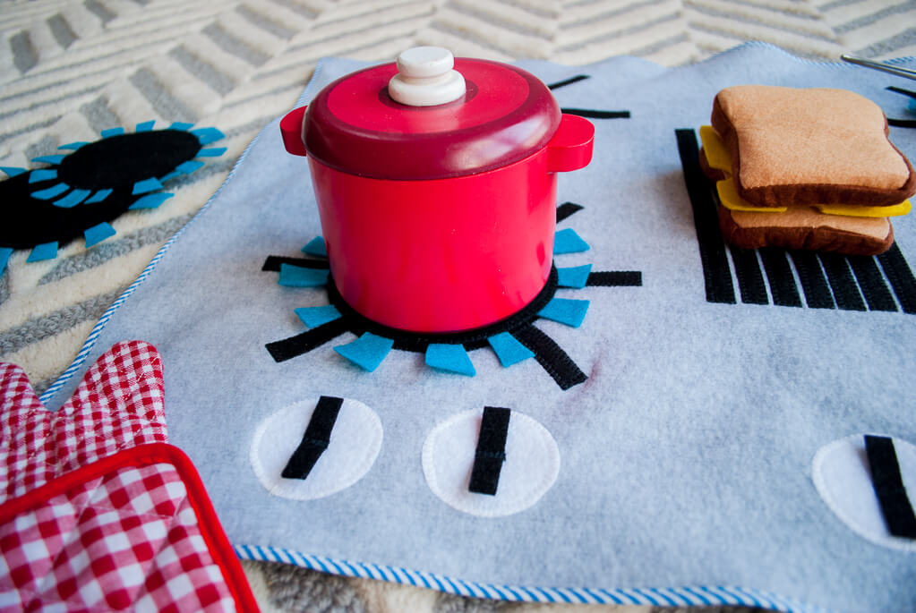 Felt and fleece stove DIY kids play kitchen with detachable felt "burners." It's flat, so you can put it anywhere and roll it up to store away. What a great kids DIY Christmas gift idea! | DIY play kitchen | DIY felt stovetop | DIY felt oven #diygifts #christmas #sewing #freesewingpattern #sewingpattern #DIY #diyforkids