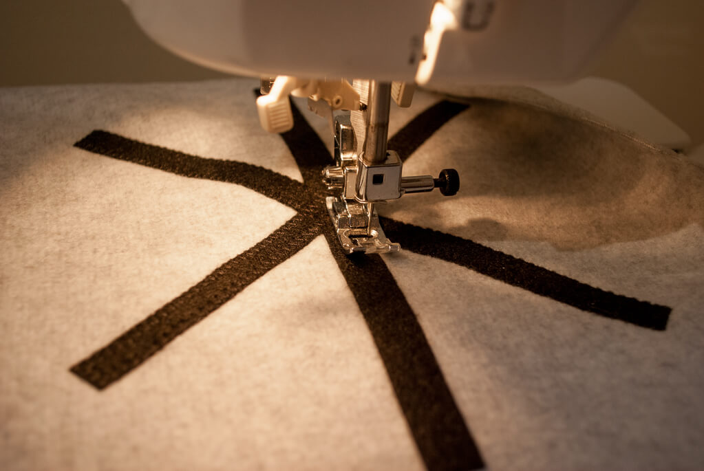 How to make a portable flat DIY play kitchen stove from felt and fleece. Zigzag the edges of the felt onto the fleece. Next, you'll add the burners.