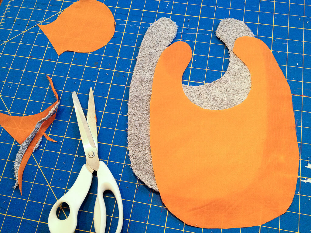 DIY free baby bib sewing pattern - it's lined with water-resistant fabric to keep baby's clothes and skin dry to catch drool and prevent chapping when baby is teething
