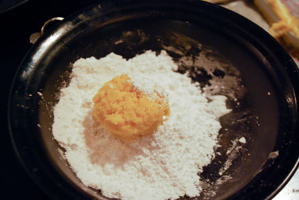 Rolling ooey gooey butter cookies in powdered sugar