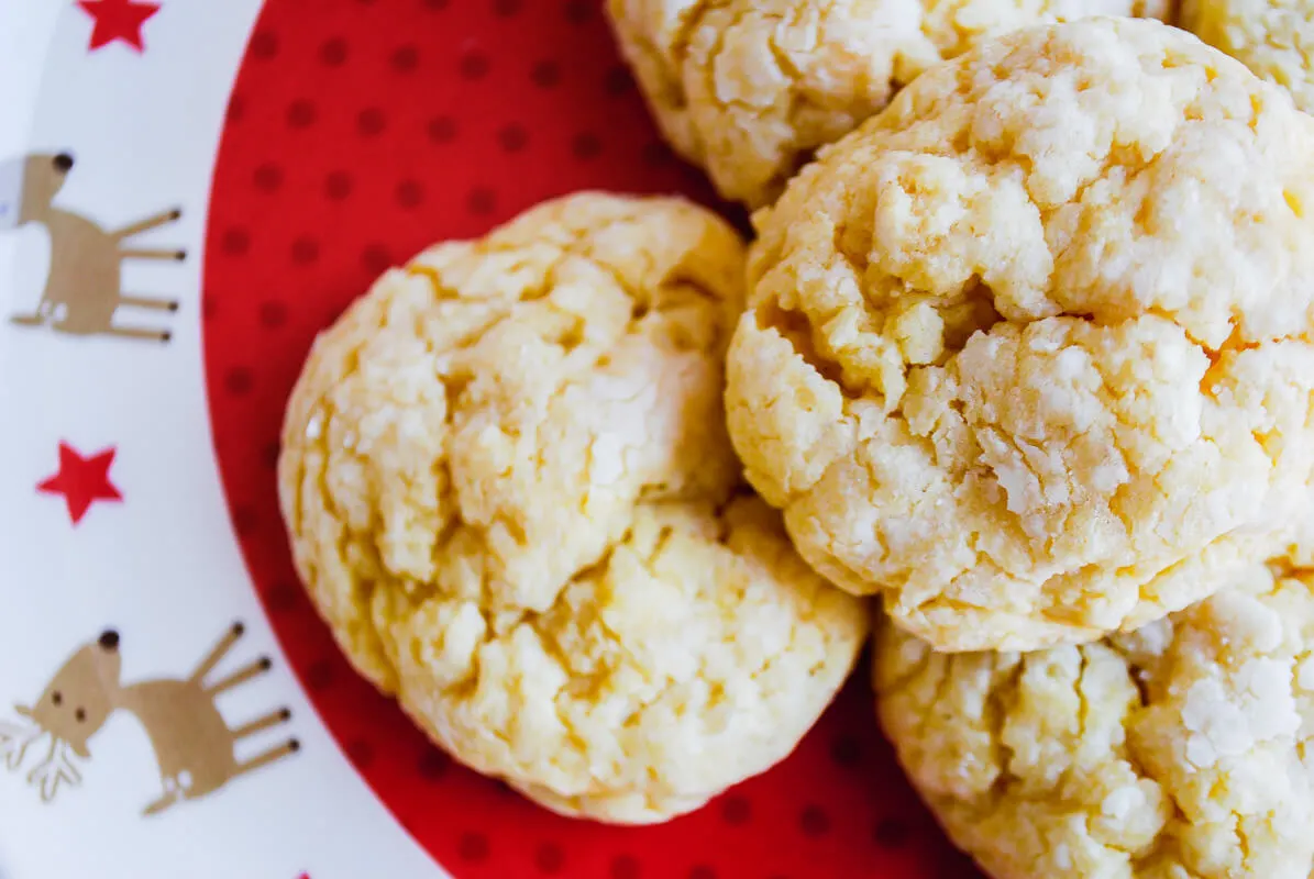 Ooey gooey butter cookies recipe - you'll never guess that these delicious cookies come from a yellow cake mix! Make these St. Louis quick and easy cake mix cookies from scratch for Christmas cookie exchanges and school celebrations. #ooey #gooey #butter #cookies #recipe #cake #mix #easy #yellow #christmas #scratch