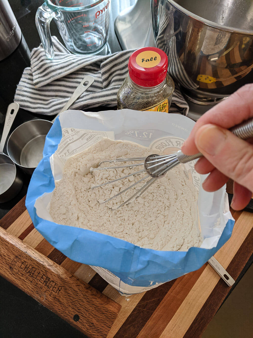 Aerating flour with a whisk before measuring