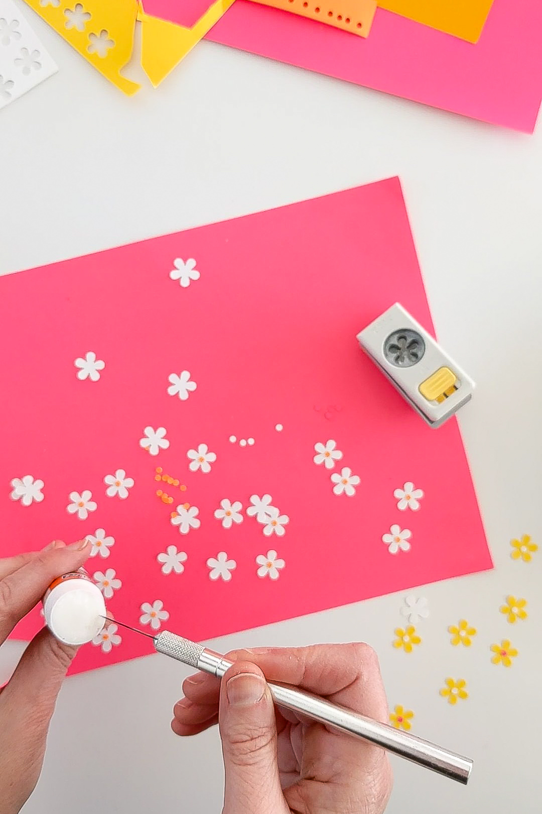 Using a craft knife to put glue onto paper flowers