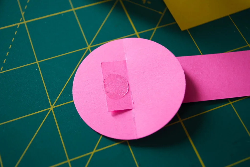 Putting a glue dot on a paper basket handle