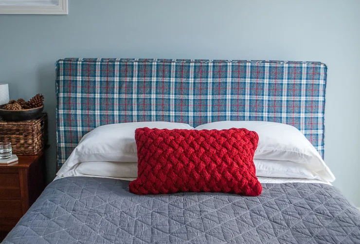 How to make a DIY headboard slipcover with a super cute storage pocket. What a cute way to temporarily update a bedroom! You can hack an IKEA Malm bed or make the slipcover for your own headboard!