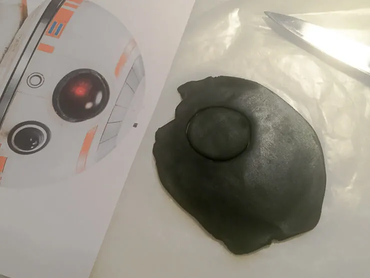 Cutting fondant for a BB-8 birthday cake
