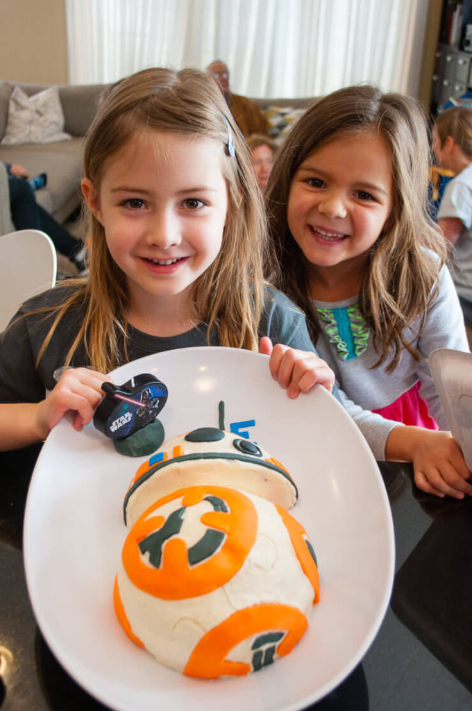 Girl holding her BB-8 Star Wars birthday cake