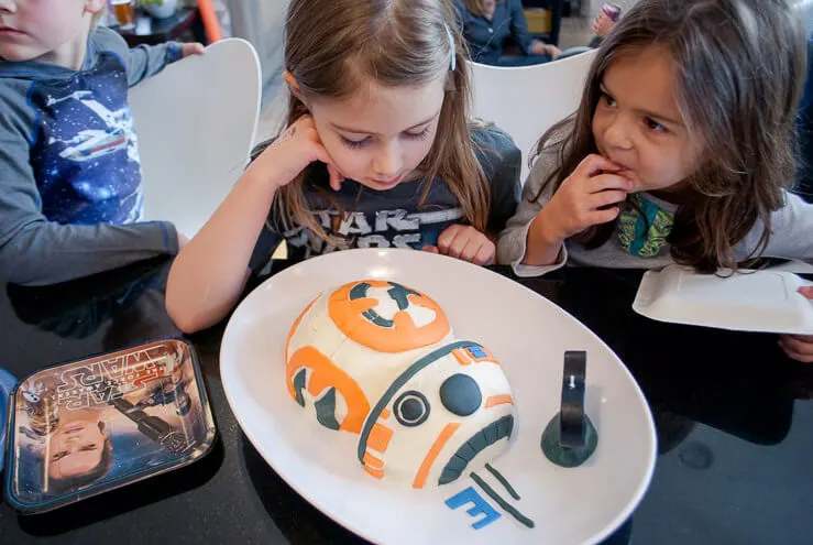 Girl looking at BB-8 birthday cake