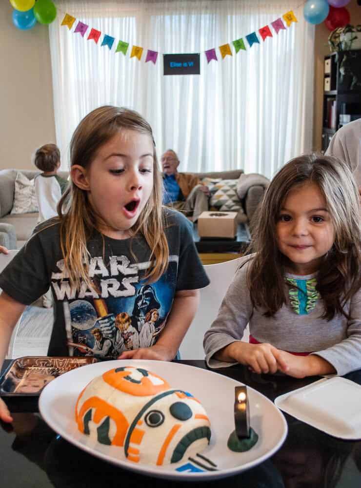 Blowing out candles on a Star Wars birthday cake