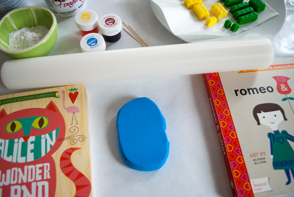 Easy hack for rolling out fondant LEGO bricks: Put a rolling pin on top of two books the same height to create thick edible LEGO bricks cake decorations #legobirthday #legocake #cakes #birthdaycakes #fondant