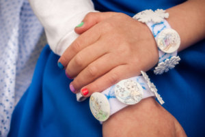 DIY Frozen charm bracelets. Great kid's activity for a Frozen birthday party or a Frozen Halloween costume idea #frozen #elsa #frozenbirthday #kidsactivity #kidscraft #craft #diy