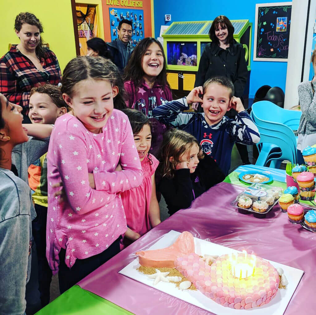 Elise with mermaid birthday cake singing happy birthday to you