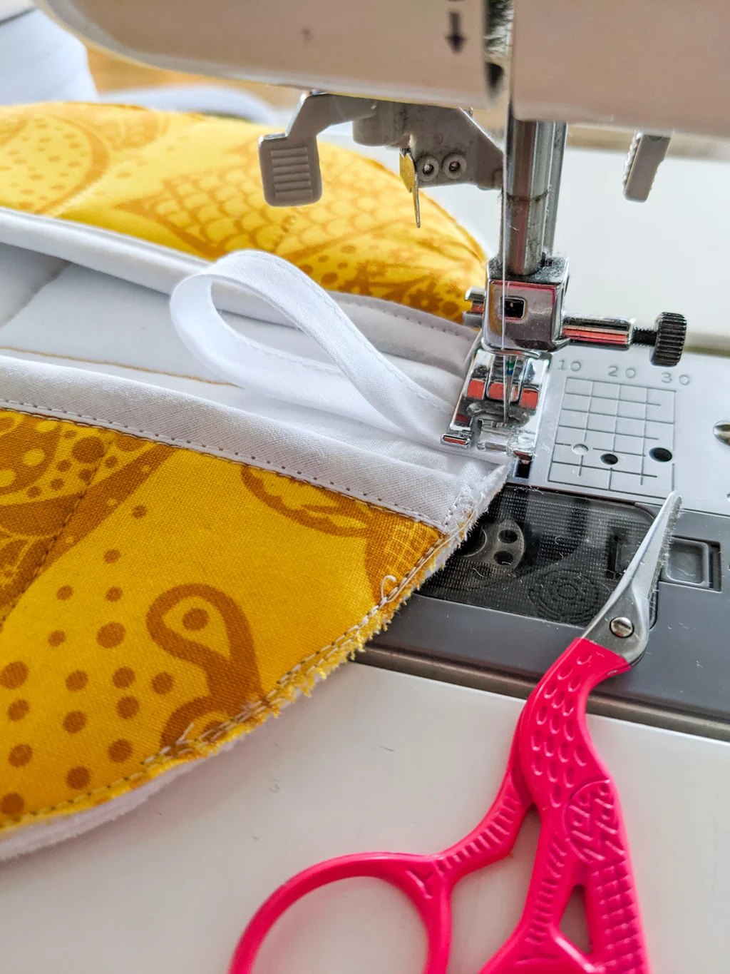 Sewing binding tape onto a round potholder for a hook