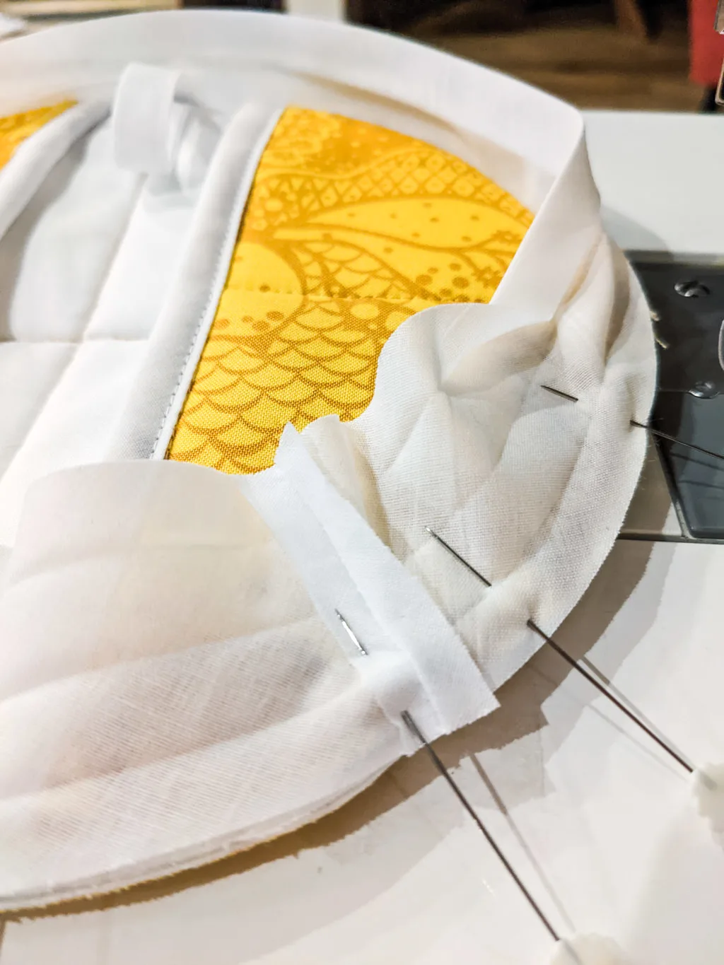 Sewing binding tape onto a DIY quilted potholder