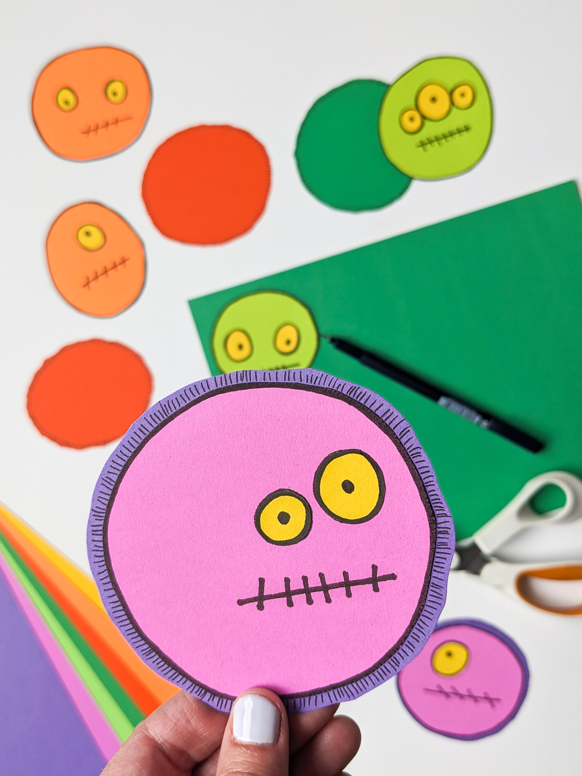 Purple monster with yellow eyes drawn on paper to make a DIY Halloween wreath