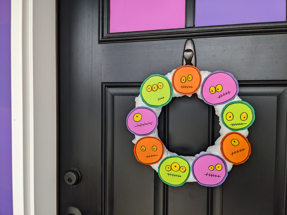 DIY Halloween Monster Wreath in purple, green, and orange on a black front door
