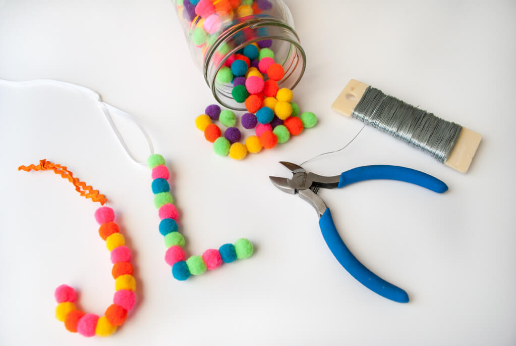 DIY pom pom letter ornaments - string pom poms on floral wire to make handmade Christmas ornaments with initials and monograms. Makes a easy DIY Christmas gift #christmasornament #handmadechristmas #pompoms