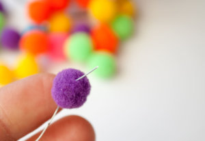 String mini pom poms onto floral wire