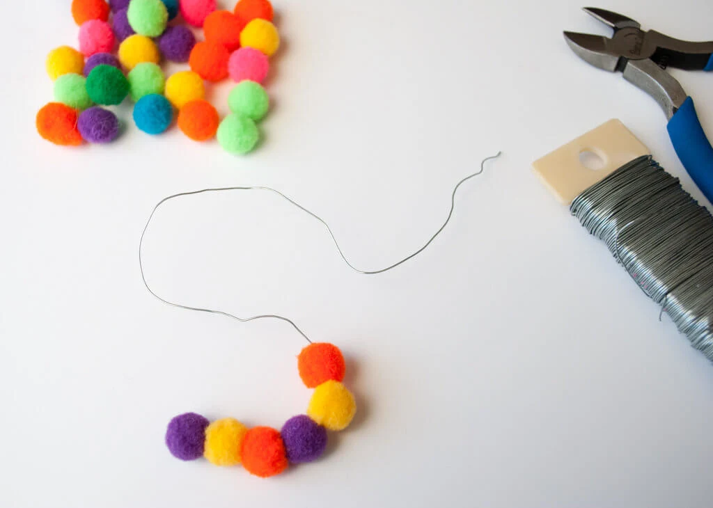 Use floral wire to string pom poms into initials, letters and monograms
