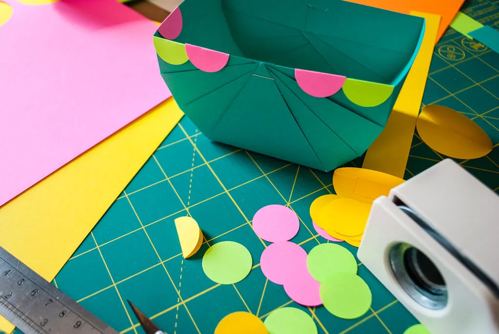 Decorating a paper Easter basket with scalloped edges