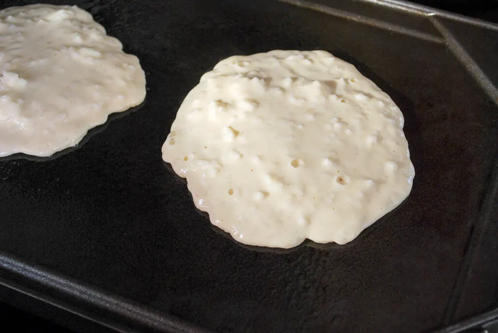 Rice pancakes cooking on a griddle
