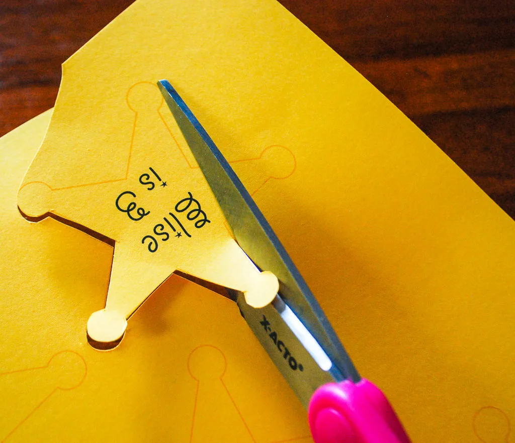 Cutting out paper sheriff badges with scissors