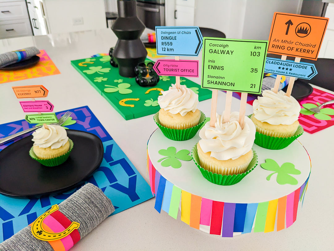 St. Patrick's Day cupcakes with Irish road signs cupcake toppers with green cupcake liners sitting on a DIY rainbow cake stand