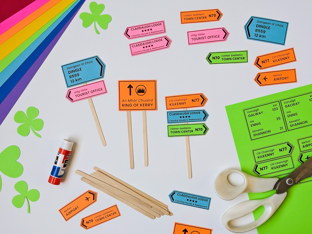 Making cupcake toppers for St. Patrick's Day using colorful paper and wooden coffee stir sticks