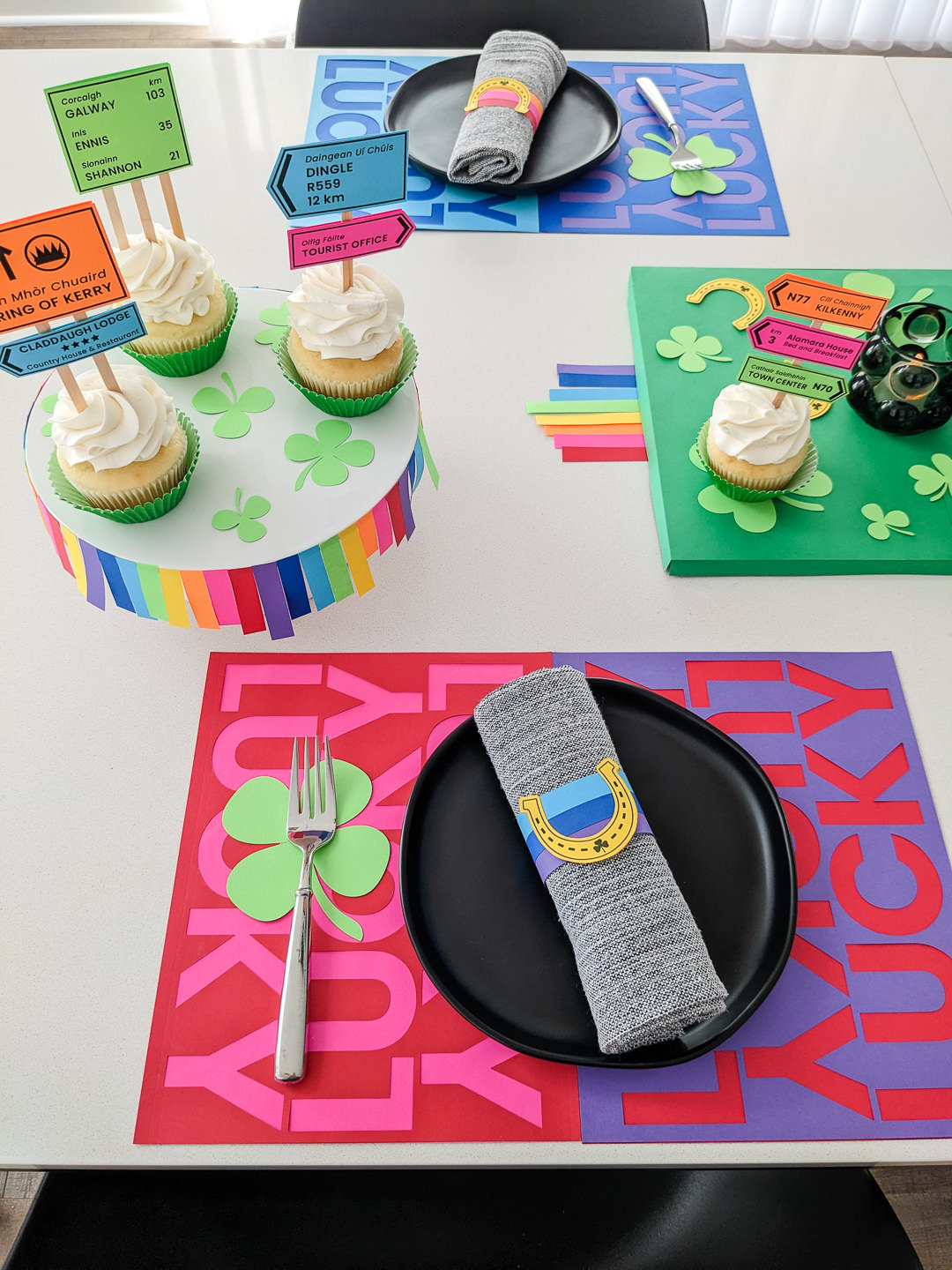 DIY St. Patrick's Day table decor: Rainbow and horseshoe paper napkin rings, lucky rainbow placemats, and Irish road signs cupcake toppers