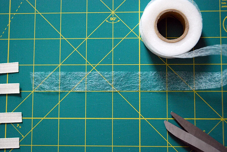 Use iron-on fusible web to adhere grosgrain ribbon to a DIY football t-shirt