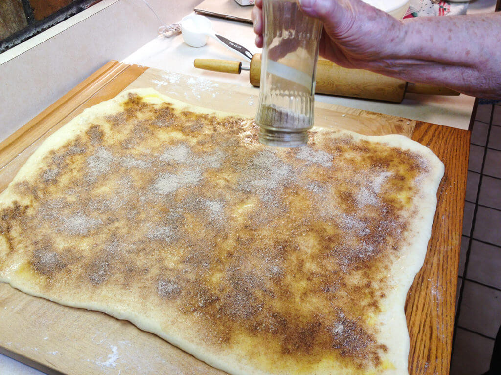 Adding cinnamon sugar to Swedish Tea Ring dough