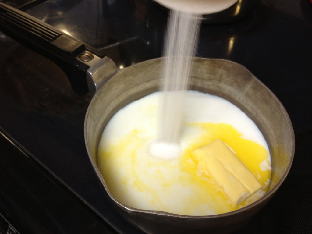 Adding sugar and butter to milk