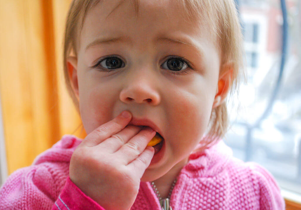 Toddler eating sweet potato crackers