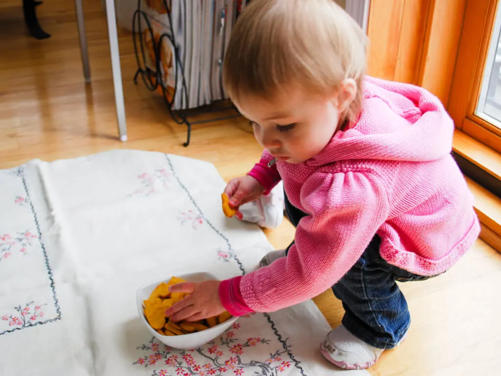 Toddler grabbing sweet potato cracker