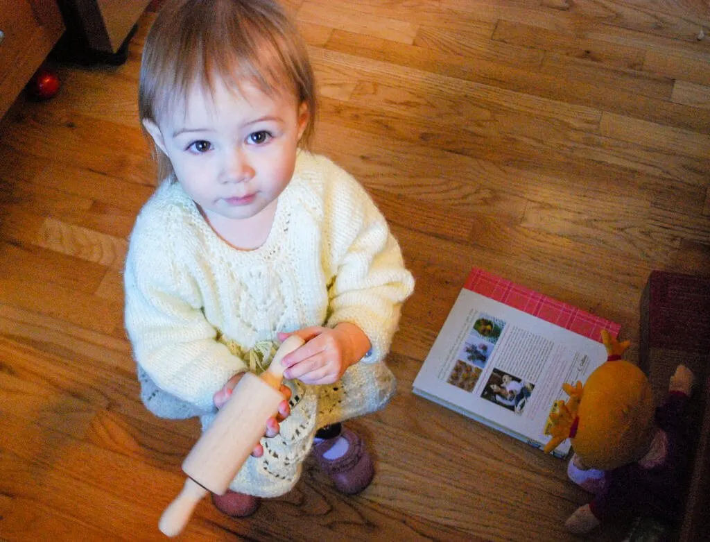 Toddler holding rolling pin