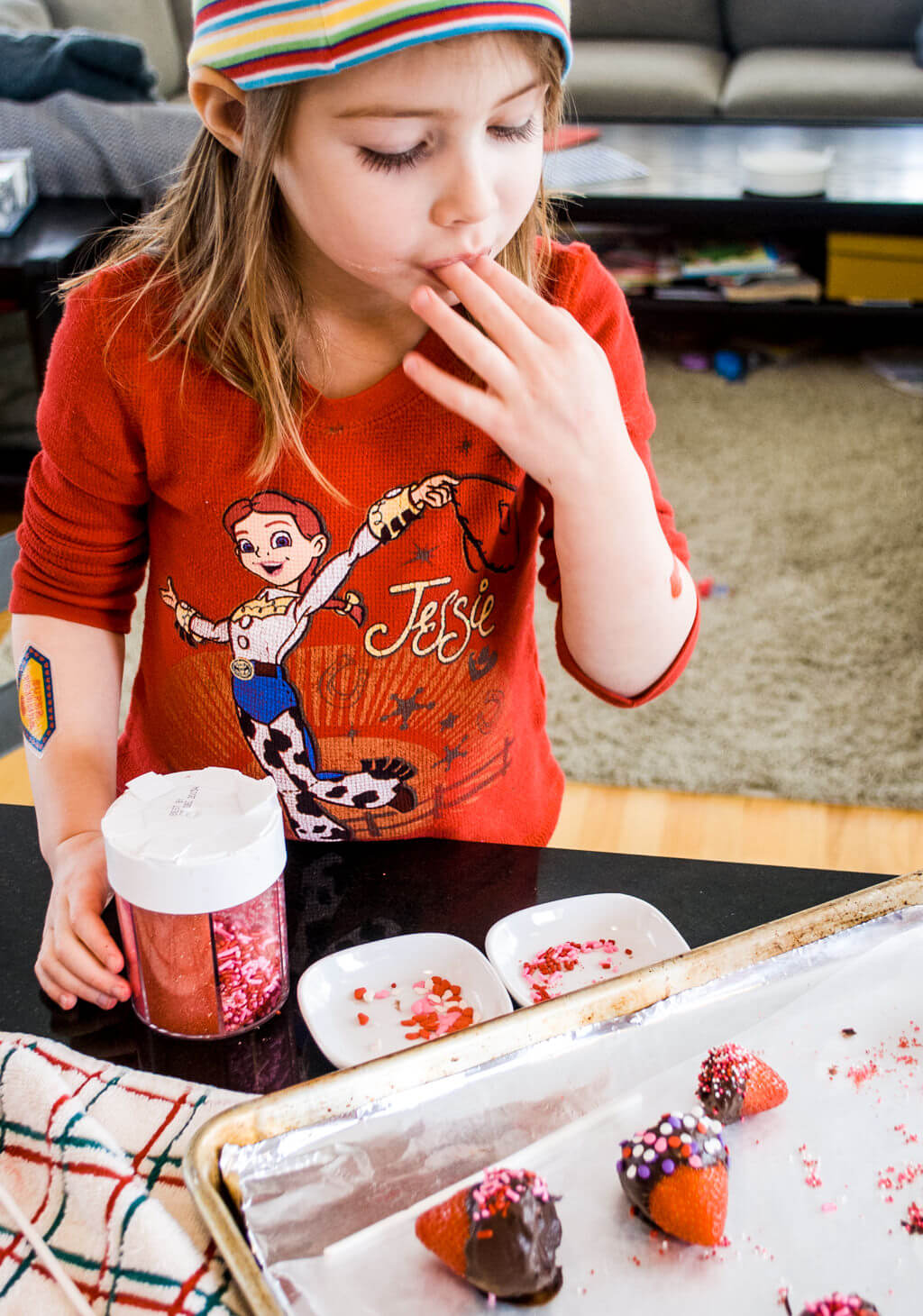 Elise putting sprinkles on chocolate strawberries. Copyright Merriment Design Co. Do not use without written permission.