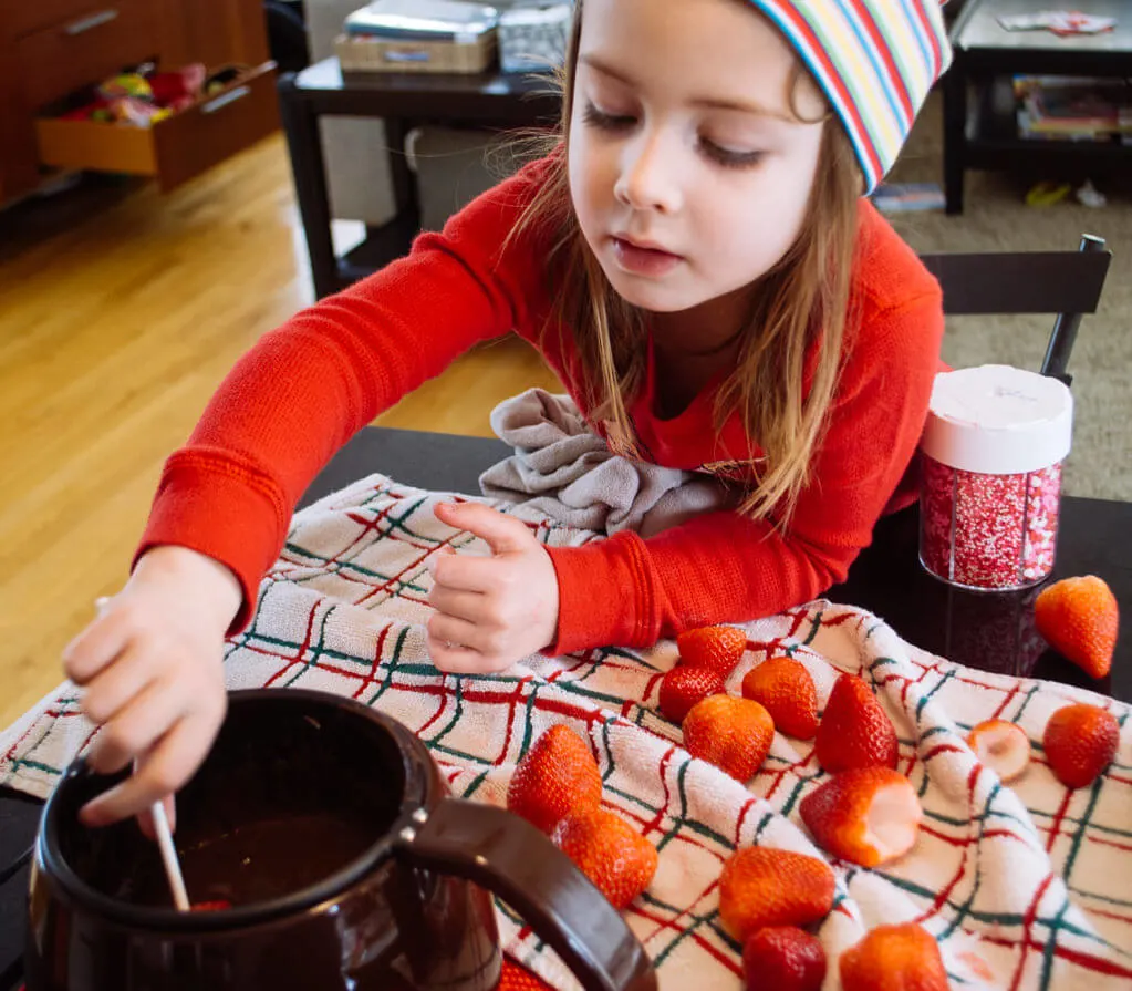 Elise dipping strawberries in chocolate. Copyright Merriment Design Co. Do not use without written permission.